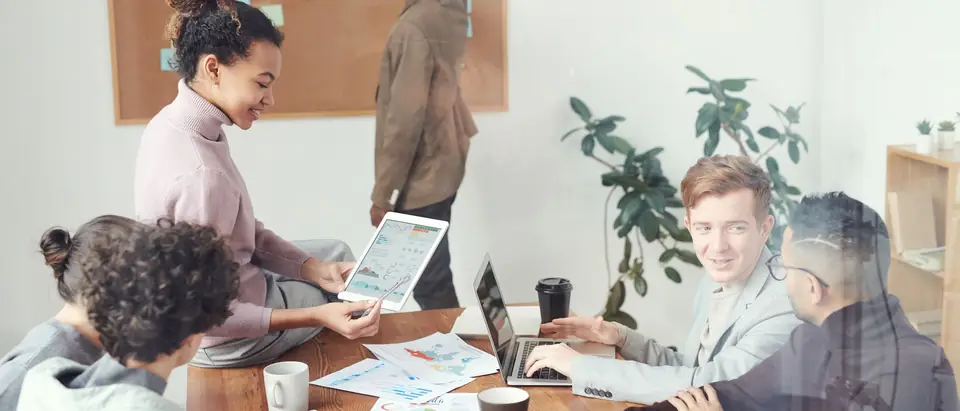 A team planning around a table covered in papers and sticky notes in a bright office