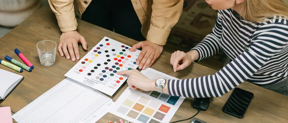 Two people choosing color samples and swatches at a table