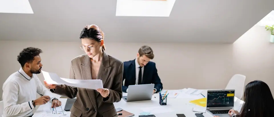 A small team at work around a long table in a bright office