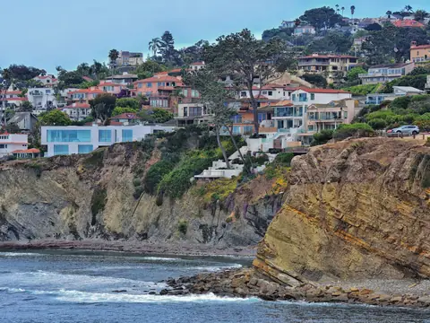 Hillside homes above the rocky San Diego coast on a sunny day