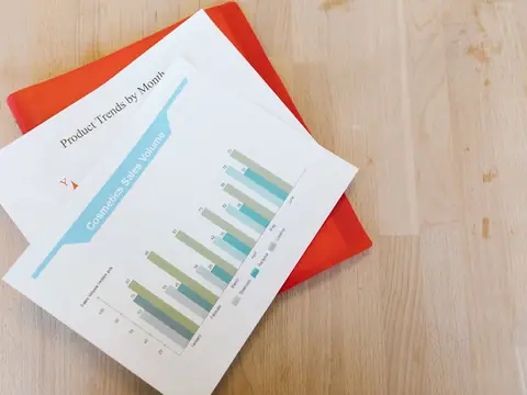 A printed report with bar charts on a light wooden desk