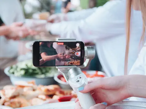 Filming a table of dishes with a phone on a handheld stabilizer