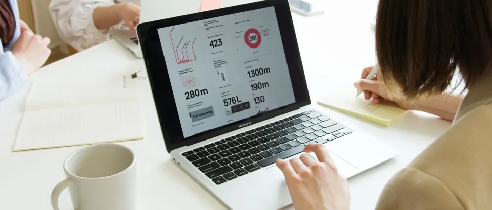 A laptop showing a website analytics dashboard on a bright desk